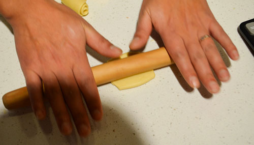 Clarissa flattening the cylinder of dough